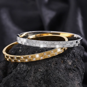 Detail of gold and silver waffle-textured titanium bracelets with sparkling cubic zirconia