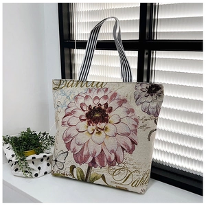 Detail shot of canvas tote bag with Dahlia print and black-and-white striped handle