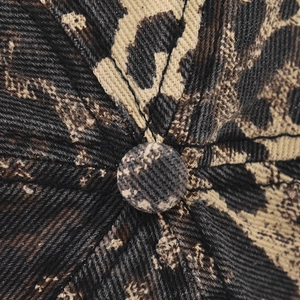 Macro detail of cotton twill baseball cap top button with classic leopard print pattern