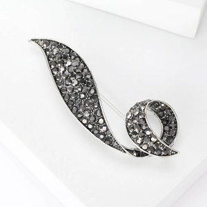 Close-up of vintage gun-black brooch with sparkling dark grey rhinestones on a white background