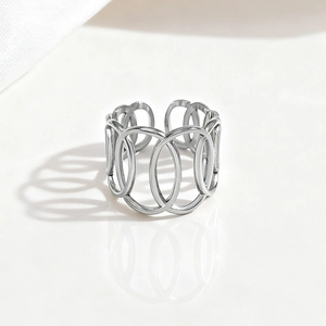 Macro detail of silver minimalist cutout ring with overlapping bands on white background