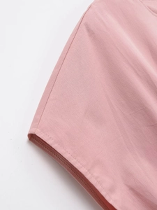 Vue détaillée du tissu rose et des coutures professionnelles sur le poignet de la robe
