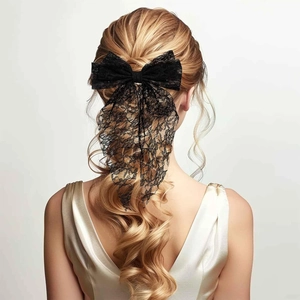 Elegant black lace bow hair clip with long ribbons on blonde wavy hair