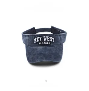 Detailed view of sun visor hat with Key West embroidery on washed navy denim fabric