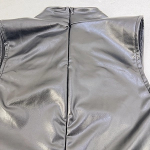 Dettaglio del retro di un abito in pelle PU nera con chiusura a cerniera invisibile