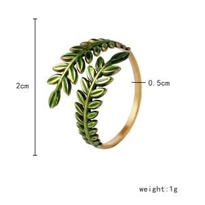 Detail of vintage gold open ring with green leaf design and dimensions 2cm by 0.5cm