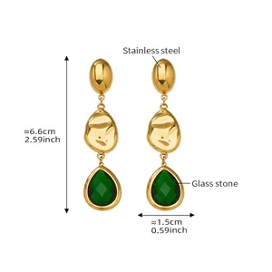 Detail view of long teardrop earrings with green glass stone and 18k gold-plated steel