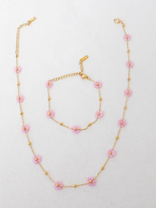 Detail view of gold stainless steel necklace with pink flower beads and lobster clasp