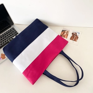 Flat lay of a tri-color patchwork canvas tote bag with navy, white, and pink segments