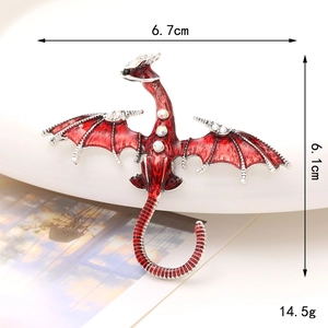 Red enamel dragon brooch with sparkling rhinestones, sized 6.7cm by 6.1cm on a white dish