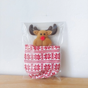 Close-up of a knitted Christmas reindeer gift bag featuring festive snowflake patterns