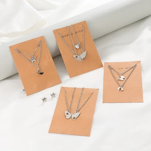 Dettaglio di set di collane in argento con farfalla e cuore su biglietti regalo