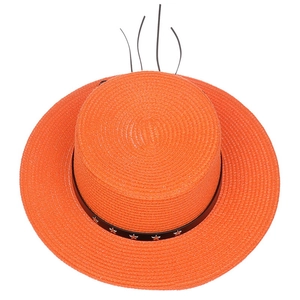 Detail of orange woven straw hat with black leather band and star metal buckle accent