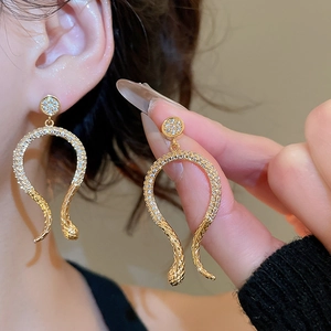 Detail of 14k gold plated snake earrings with shimmering pavé cubic zirconia