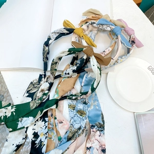 Close-up of floral fabric bow headbands in various colors with white wavy edges