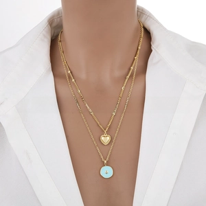 Detail of a double-layered 18K gold-plated necklace with blue enamel star pendant on a model