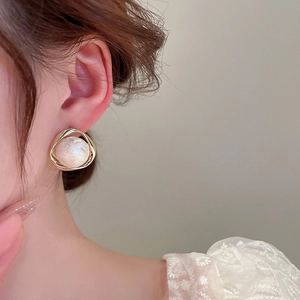 Elegant geometric gold pearl stud earrings featuring a minimalist hollow twisted metal frame