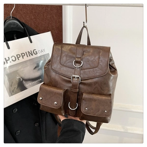 Detail of dark brown vintage leather backpack with front pockets and silver buckles