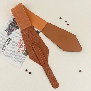 Flat lay of wide caramel elastic belt with crocodile texture faux leather and pin buckle