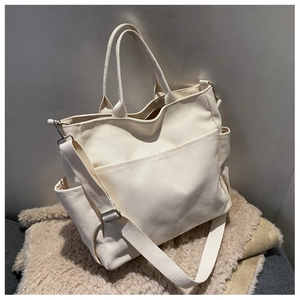 Large capacity cream canvas tote bag with adjustable shoulder strap and side pockets