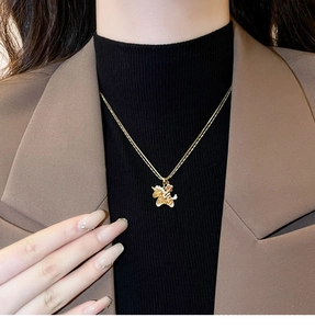 Close-up of golden unicorn necklace with cubic zirconia crystals worn by a model
