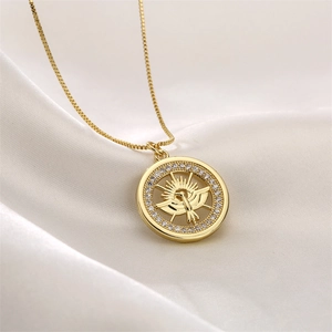 Detailed close-up of golden box chain necklace with zircon-encrusted angel pendant