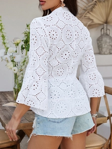 Détails de dos d'une blouse blanche brodée avec des manches et un ourlet à volants