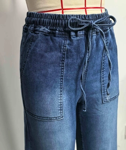 Detail van elastische taille met trekkoord op donkerblauwe gewassen wijde jeans