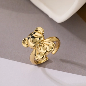 Detailed macro view of a 3D gold-plated teddy bear ring with an adjustable open band