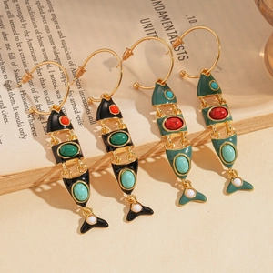 Vintage enamel fish bone drop earrings with turquoise inlays on an open book