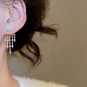 Detail of 14K gold plated tassel earrings with white pearls and marquise cut cubic zirconia