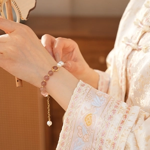 Detail of strawberry crystal and pearl beaded bracelet on model in New Chinese Style attire