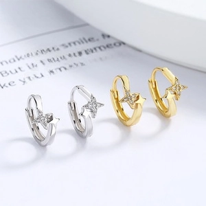 Detail view of gold and silver star-shaped earrings with micro-inlaid sparkling zircons