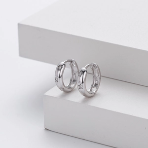 Macro detail of S925 sterling silver hoop earrings with hollow stars and micro zircons