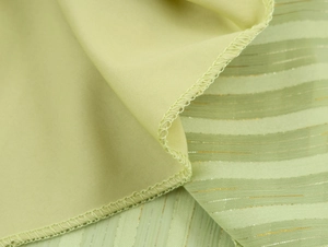 Detailed macro view showing light green striped fabric texture with subtle gold metallic thread