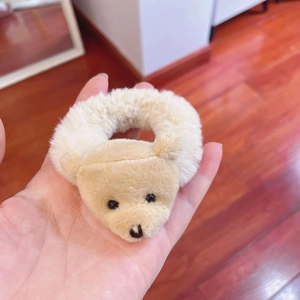 Detailed view of a soft cream plush bear hair tie with a fuzzy texture and cute design