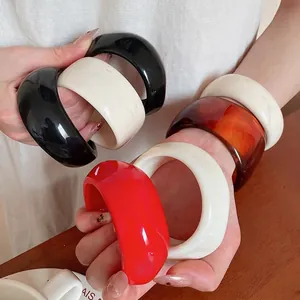 Chunky acrylic resin cuff bracelet in black cream and amber for minimalist styling