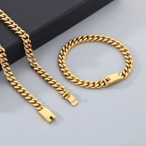 Detailed shot of golden Cuban link necklace and bracelet set with rectangular clasp