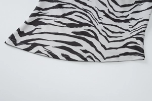Detail of high-quality stitching and zebra print fabric on the hem of a stylish top