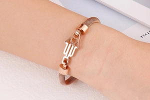 Détail d'un bracelet en maille or rose avec main de Fatma et découpe cœur au poignet