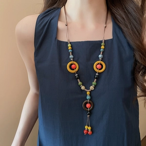Close-up of bohemian ceramic beads and woven tassels on a vintage ethnic necklace