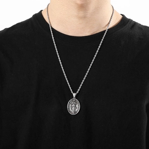 Silver stainless steel Virgin Mary pendant necklace with twisted chain on a black shirt