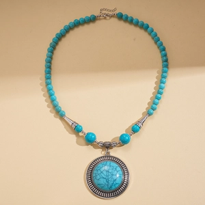 Detail of bohemian long necklace with round turquoise beads and large silver alloy pendant