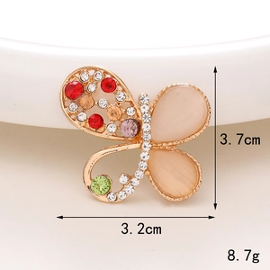 Dettaglio macro di un ciondolo a farfalla con strass colorati e misure del prodotto