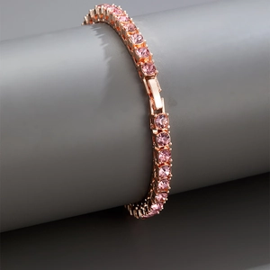 Macro shot of rose gold tennis bracelet featuring rows of pink cubic zirconia stones