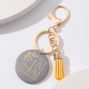 Detail of wooden Mama keychain with leopard print text and yellow leather tassel