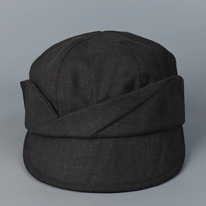 Detail of black cotton linen newsboy cap featuring unique cross-pleat decorative brim