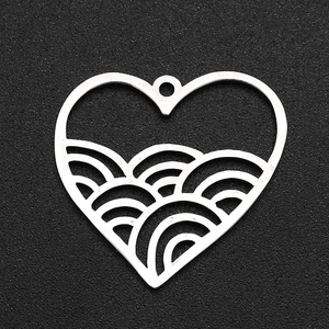 Detailed view of a silver heart pendant with hollow wave pattern in polished stainless steel