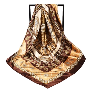 Detail of silk-texture square scarf with brown paisley pattern and golden border