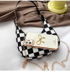 Detailed view of checkered crescent bag capacity compared with a smartphone